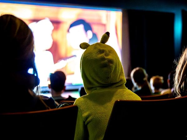 Kinder schauen auf eine Kinoleinwand.