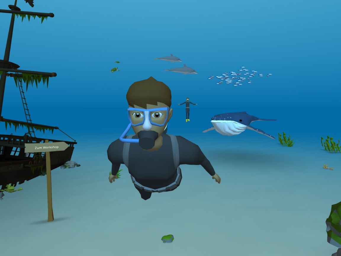 Virtuelle Unterwasserwelt. Eine Taucherin schaut in die Kamera, dahinter verschiedene Meerestiere.