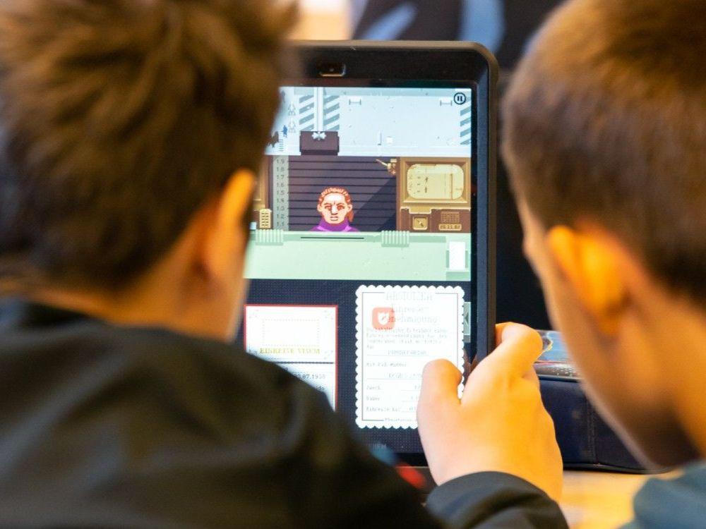 Zwei Kinder spielen gemeinsam an einem Tablet.