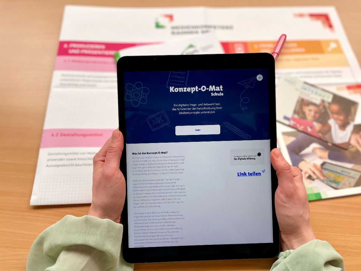 Person hält Tablet mit Konzept-O-Mat. Im Hintergrund ist der Medienkompetenzrahmen NRW zu sehen. Person hält Tablet mit Konzept-O-Mat. Im Hintergrund ist der Medienkompetenzrahmen NRW zu sehen.