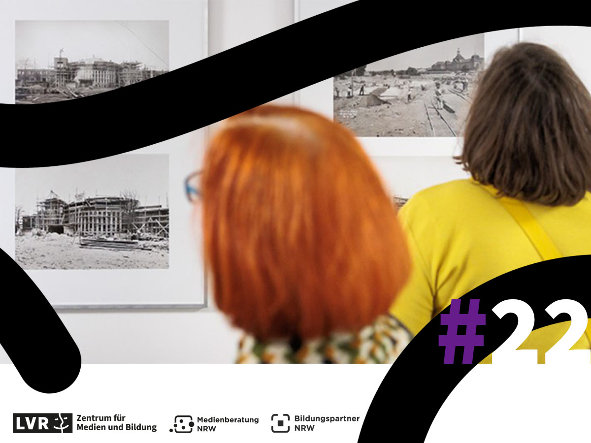 Zwei Frauen sehen sich gerahmte Fotos an, die an einer Wand hängen. Weiter unten sind zudem die Logos der Herausgeber des Newsletters zu sehen sowie die Ausgaben 22.