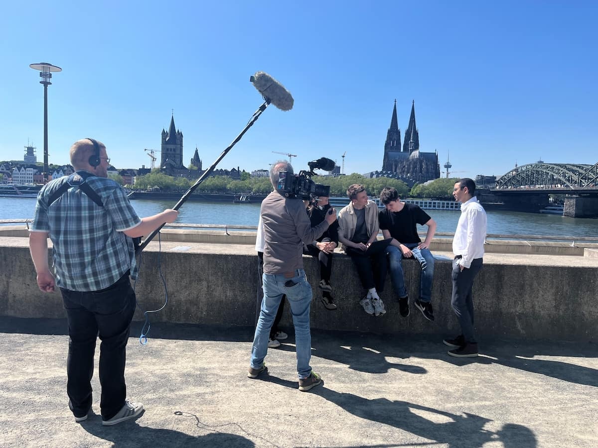 Ein Kamerateam filmt Auszubildende an der Kölner Rheinpromenade. Ein Kamerateam filmt Auszubildende an der Kölner Rheinpromenade.