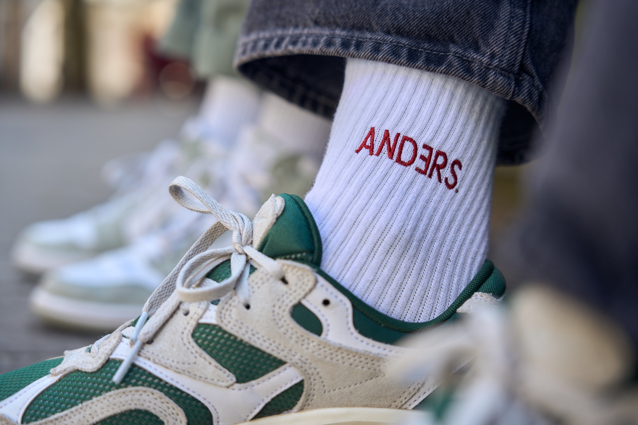 Bildausschnitt zeigt weiße angezogene Socke mit Schriftzug "Anders" in grün-weißem Turnschuh. Bildausschnitt zeigt weiße angezogene Socke mit Schriftzug "Anders" in grün-weißem Turnschuh.